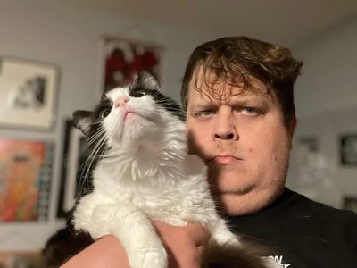 Neal Bushaw, holding a large tuxedo cat